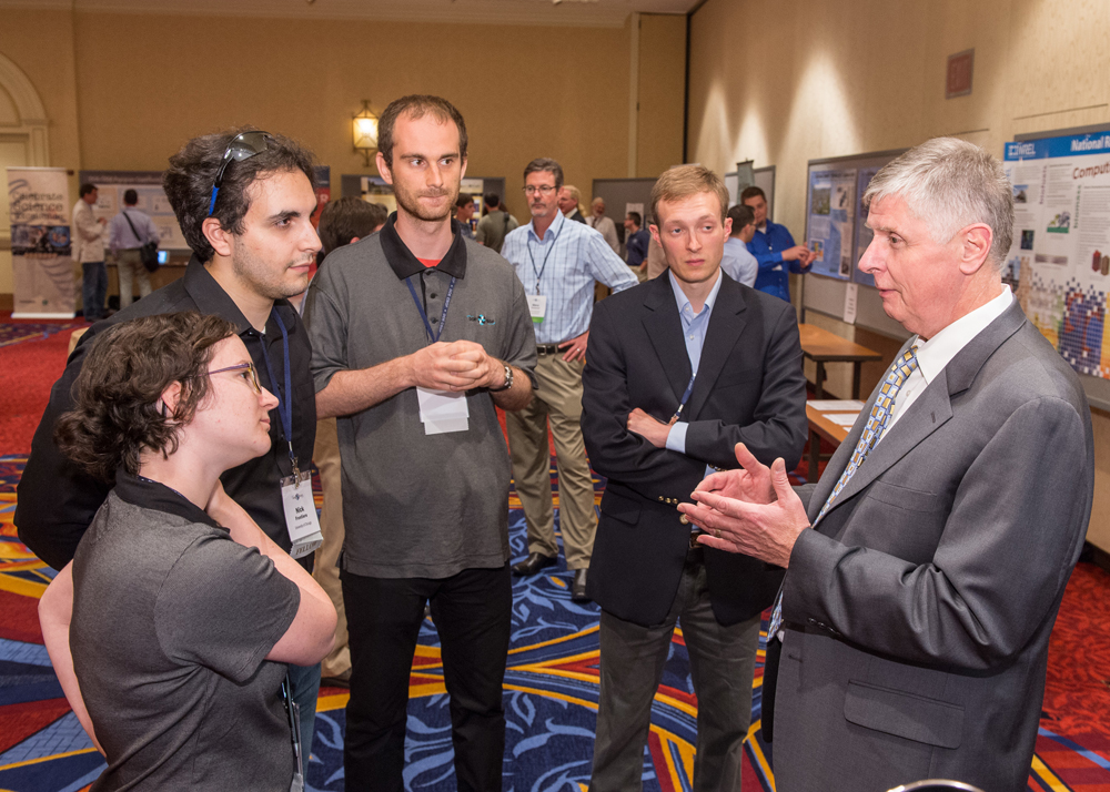 DOE NNSA's Don Cook (right) welcomed fellows, alumni and friends to the 2013 DOE laboratory poster session.